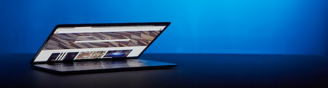 a laptop on a table with a neon background showing a website refresh